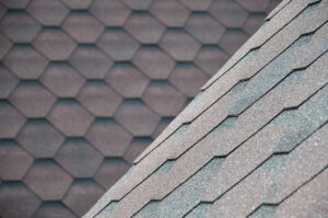 The texture of the roof with bituminous coating. Rough bituminous mosaic of red and brown flowers. Waterproof roofing